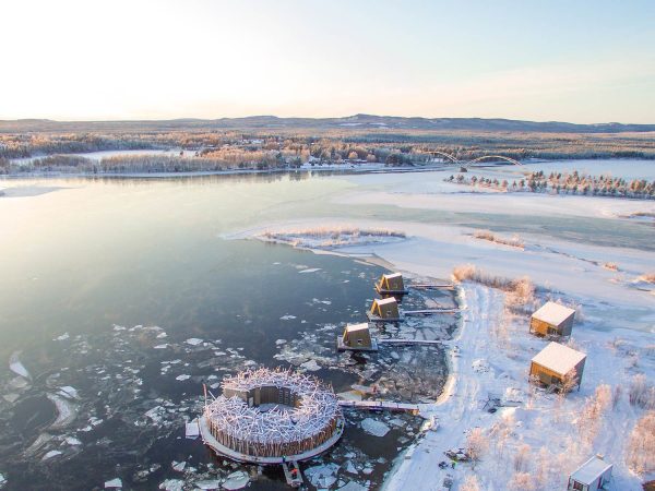 Bru & Bru agencia de viajes exclusivos - Arctic Bath Hotel Spa flotante en Laponia, Suecia. Vista aérea del hotel en el río al atardecer